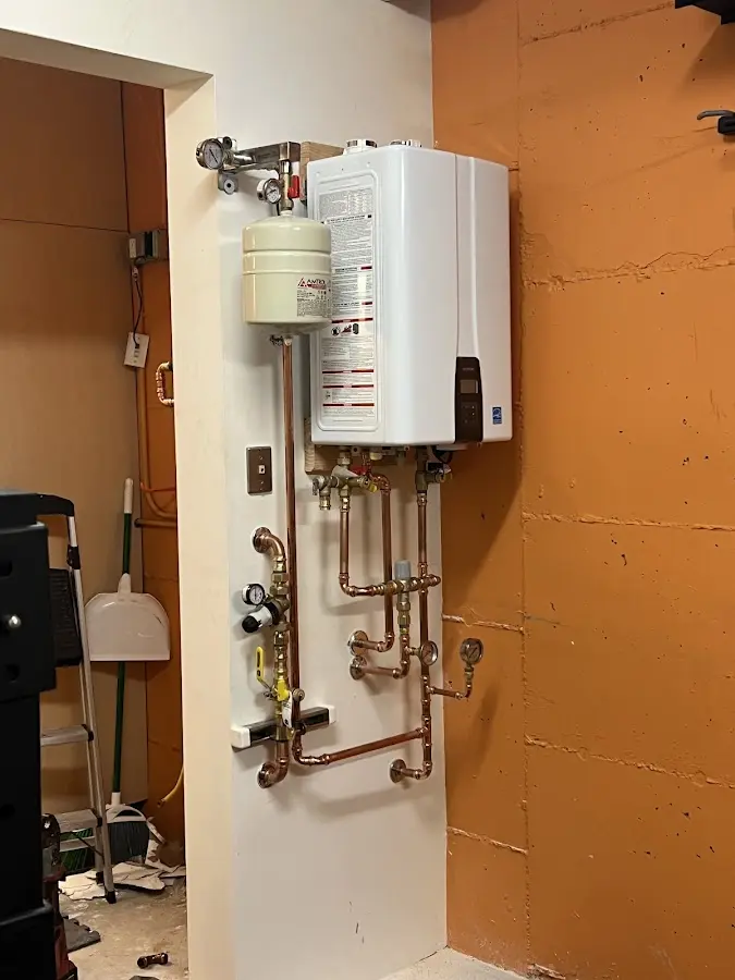 Plumbing technician inspecting water heater connections in Pinehurst